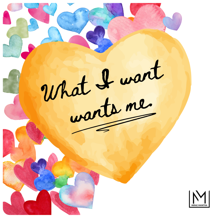 Heart-shaped yellow card with 'What I want wants me' text, surrounded by colorful watercolor hearts. Mirae Mantra mirror affirmation sticker.