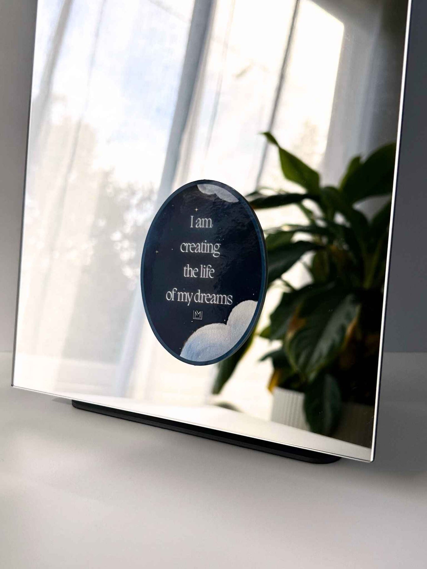 Celestial-themed mirror manifestation affirmation reading “I am creating the life of my dreams”