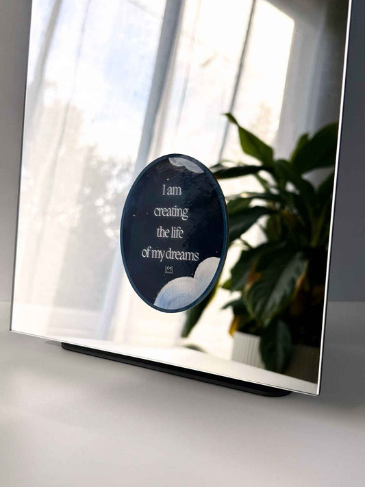 Celestial-themed mirror manifestation affirmation reading “I am creating the life of my dreams”