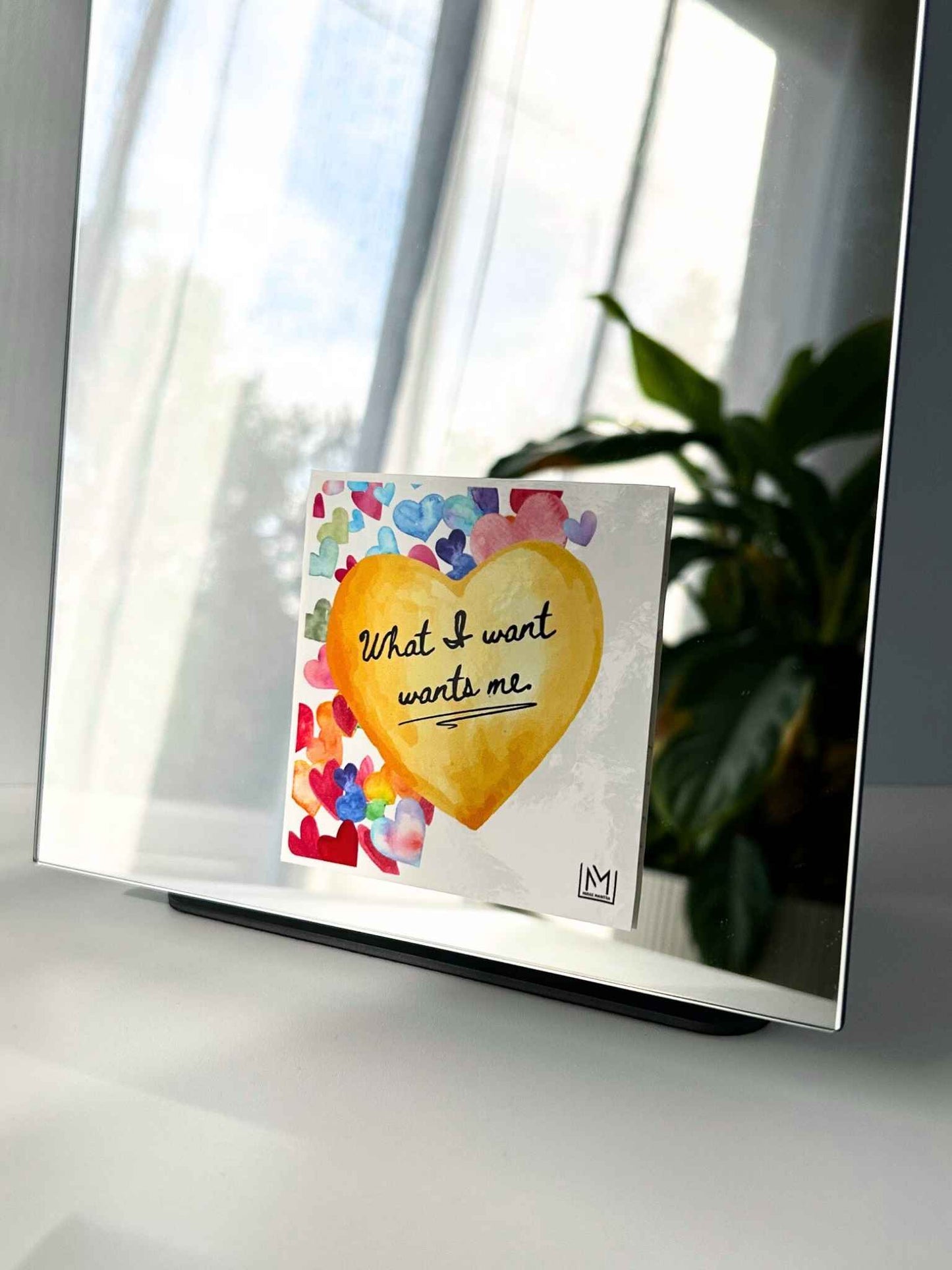Heart-shaped mirror manifestation affirmation reading “What I want wants me”